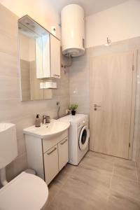 uma casa de banho com um lavatório e uma máquina de lavar roupa em MiKa em Kaštela