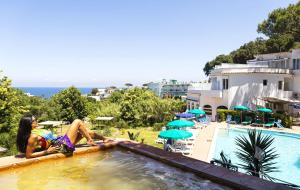 a woman sitting in a swimming pool at a hotel at Bristol Hotel in Ischia