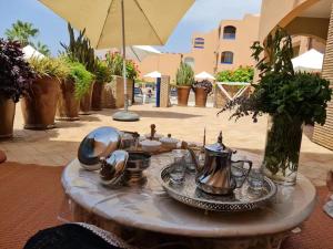 - une table avec des assiettes et des théières dans l'établissement Paradis Plage Pieds dans l'eau - Superbe Appartement, à Agadir