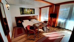 una camera da letto con un letto e un tavolo con sedie di Gasthof Hammerschmiede a Bischofsgrün