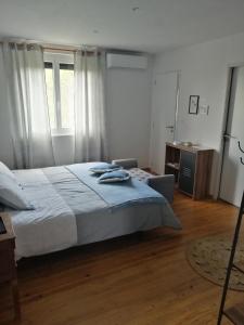 a bedroom with a bed and a chair and window at Le domaine de Moïse in La Fouillade