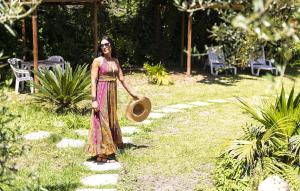 a woman standing in a garden holding a hat at Bristol Hotel in Ischia