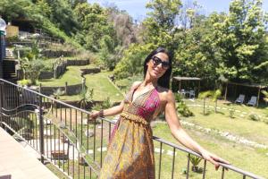 a woman in a dress standing next to a fence at Bristol Hotel in Ischia