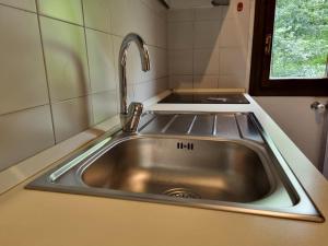 un fregadero de acero inoxidable en una pequeña cocina en Appartamento EdenSirente en Rocca di Cambio