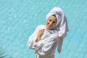 a woman in a towel standing next to the water at Bristol Hotel in Ischia
