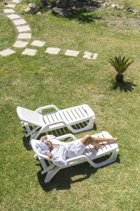 two people laying on lounge chairs on the grass at Bristol Hotel in Ischia