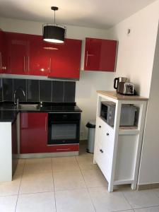 マント・ラ・ジョリーにあるApparemment 003のキッチン(赤いキャビネット、カウンタートップ付)