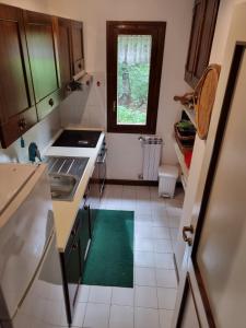 uma pequena cozinha com um lavatório e uma janela em Appartamento EdenSirente em Rocca di Cambio