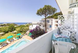 a balcony with a table and chairs and a swimming pool at Bristol Hotel in Ischia