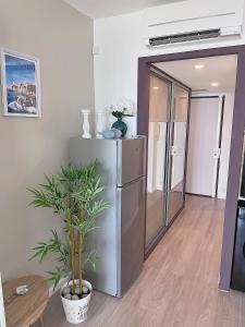 a kitchen with a stainless steel refrigerator and a plant at La perle du Grau : T1 avec exceptionnelle vue mer in Le Grau-du-Roi