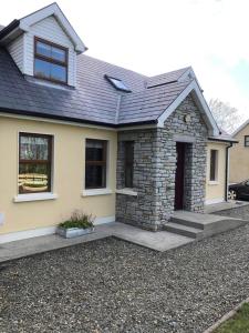 a home with a stone house with a driveway at Ballyloskey Road in Carndonagh