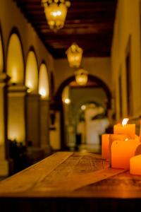 una mesa de madera con velas naranjas encima en Hotel Boutique Hacienda Guadalupe en San Miguel de Allende