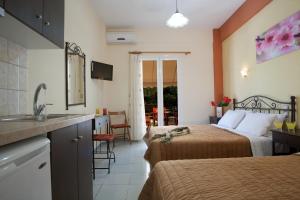 a hotel room with two beds and a sink at Natasa Studios in Mikros Gialos