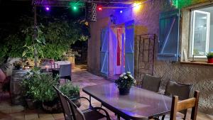 un tavolo e delle sedie su un patio con luci viola di La Bastide avec Piscine, au cœur de la Provence a Sainte-Anastasie-sur-Issole