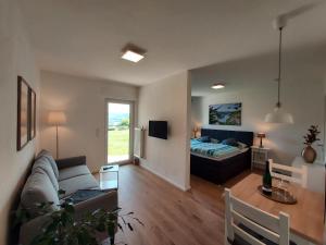 una sala de estar con un sofá y una cama en Ferienhaus Prinzenkopf, en Alf