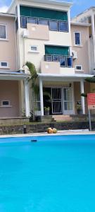 a building with a swimming pool in front of a house at Your Holiday Home in Grand Gaube