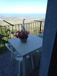 een tafel met bloemen en een vogel op een balkon bij Casa vacanze Staiti 