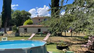 un cortile con piscina e una casa di La Bastide avec Piscine, au cœur de la Provence a Sainte-Anastasie-sur-Issole