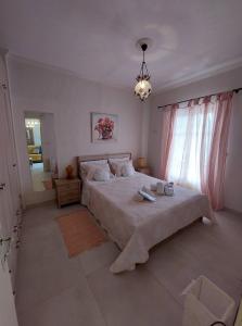 a bedroom with a large bed and a chandelier at Anatoli Apartment in Perama