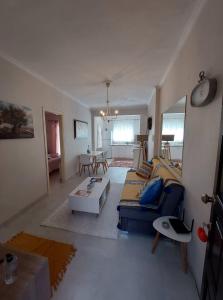 ein Wohnzimmer mit einem Sofa und einem Tisch in der Unterkunft Anatoli Apartment in Perama