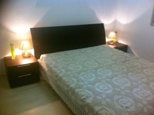 a bedroom with a bed and two night stands with lamps at Sandy Beach Apartment 8 in Voroklini