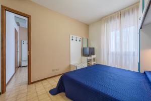 una camera con letto blu e specchio di Hotel Sanremo a Lido di Jesolo