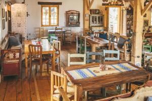 a dining room with wooden tables and chairs at Viscri 32 - White Barn and Blue House in Viscri