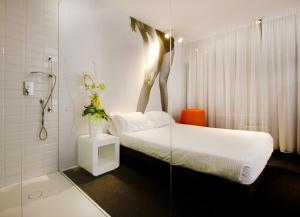 a bedroom with a bed and a shower with a statue on the wall at Green Hotel in Vergiate