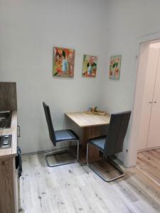 une cuisine avec une table en bois et deux chaises dans l'établissement City Apartment in Velbert-Mitte, à Velbert