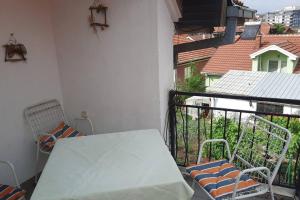 einen Balkon mit einem weißen Tisch und Stühlen in der Unterkunft Stan za iznajmuvanje so parking,blisku do centar. in Kumanovo