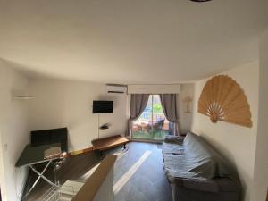 - un salon avec un canapé et une fenêtre dans l'établissement appartement au LAGON BLEU à Fréjus, garage, tennis & piscine 1200 M2, à Fréjus