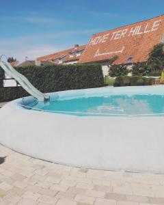 - une piscine avec toboggan dans la cour dans l'établissement Hove Ter Hille, à Jabbeke