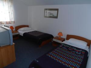 a hotel room with two beds and a television at Hotel Metković in Metković