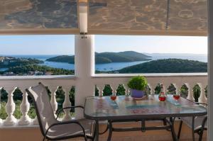 a table and chairs on a balcony with a view at Charoula's Apartments in Syvota +11 photos