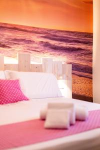 a bed with a painting of the beach at Hotel Majorca in Gabicce Mare +224 photos