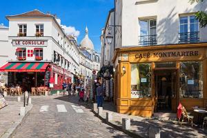 a city street with shops and people walking down the street at Cosy Studio in Montmartre in Paris