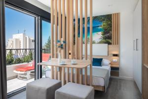 um quarto com uma cama, uma mesa e uma varanda em Villa Loriana Apartments em Makarska