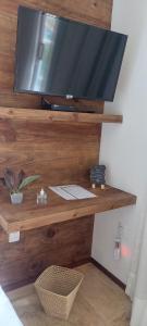 a flat screen tv on a wall with a desk at Pousada Flor de Lena- Lotus in Icaraí