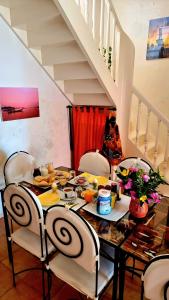 einen Esstisch und Stühle mit Essen drauf in der Unterkunft Chez Coumbis in Gorée