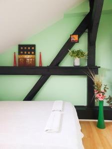 a bedroom with a white bed and a green wall at He-Ra Apartments with Free Parking in Skopje