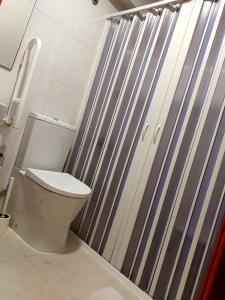 a bathroom with a toilet and a shower door at Hotel Nova Cidade in Amadora