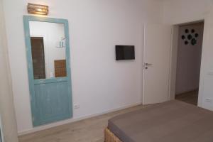 a bedroom with a blue door and a mirror at Casalina in Lido di Jesolo