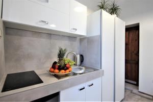 a kitchen with a bowl of fruit on a counter at Apart Studio Rambiert in Swarzewo