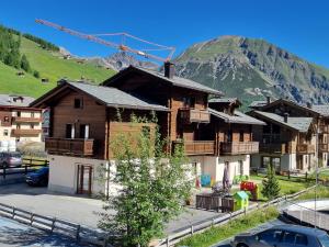 un grande edificio con una montagna sullo sfondo di Al Camanel a Livigno