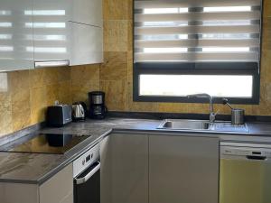 kuchnia ze zlewem i oknem w obiekcie Villa Lena w mieście Playa Blanca
