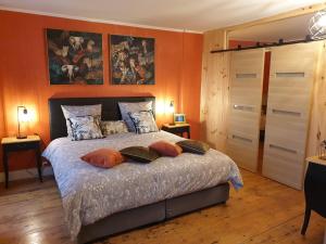 Villefranche-de-Longchat的住宿－皮格勒尼耶莊園住宿加早餐旅館，一间卧室拥有橙色的墙壁,配有一张带枕头的床。