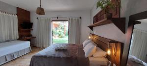 a bedroom with a bed and a large window at Pousada Flor de Lena- Lotus in Icaraí