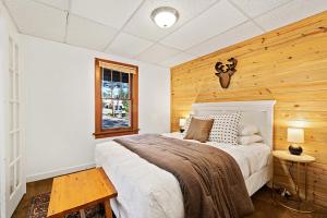 1 dormitorio con 1 cama y pared de madera en Misty Mountain Lodge, en Estes Park