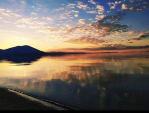 een zonsondergang boven een waterlichaam met een berg bij Beachwalk apartments in Chalkida