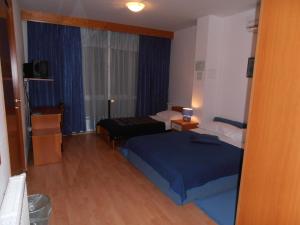 um quarto de hotel com uma cama e uma janela em Hotel Metković em Metković